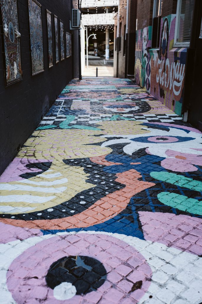 Colourful pavement and wall murals in a pedestrian laneway in Gosford CBD.